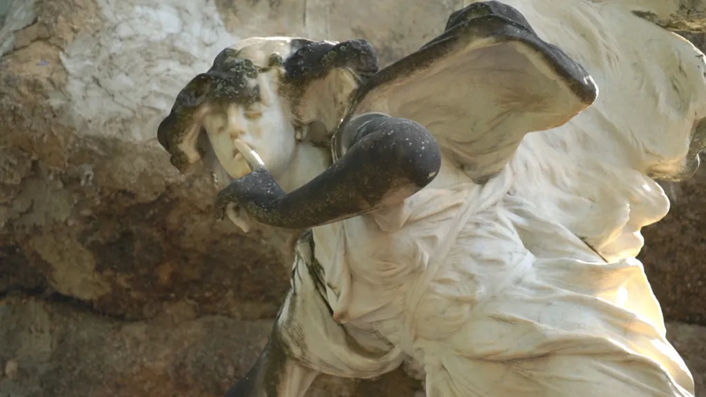 Escultura en mármol blanco de un ángel que se lleva el dedo a la boca pidiendo silencio en el Cementerio Modernista de Alcoy