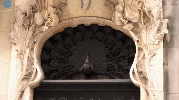 Detalle de forja sobre las puertas que represnta un pavo real. Fachada de la casa del Pavo. Modernista de Alcoy