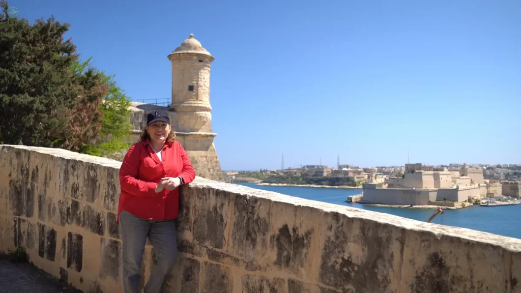 La autora del blog en los jardines Herbert Ganado de La Valeta, con la torre de vigilancia y el Gran Puerto al fondo