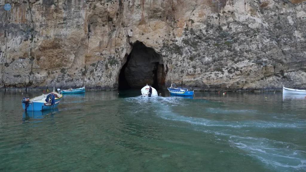 Barcas de pesca entrando por la cueva que conecta el Mar Interior de Dwejra con el Mediterráneo, en la isla de Gozo, Malta