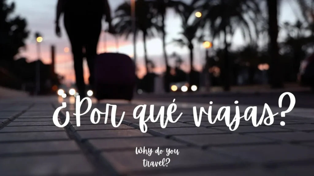 Mujer de espaldas se aleja arrastrando una maleta de ruedas hacia la puesta de sol