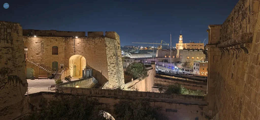 Vista nocturna de las murallas interiores de la puerta principal en Birgu (Vittoriosa), Malta, iluminadas bajo la luna