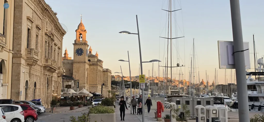 Paseo marítimo de Birgu (Vittoriosa) al atardecer, con la iglesia de San Lorenzo y el puerto deportivo frente a La Valeta al fondo