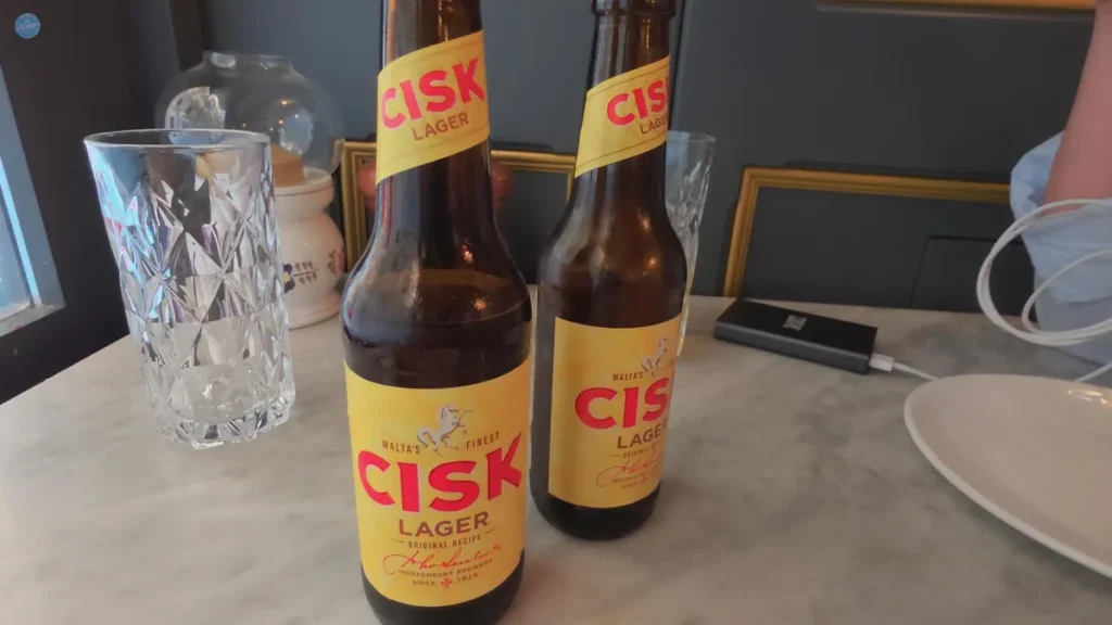 Dos botellas de Cisk Lager, la cerveza local maltesa, sobre una mesa de mármol en un restaurante de Malta