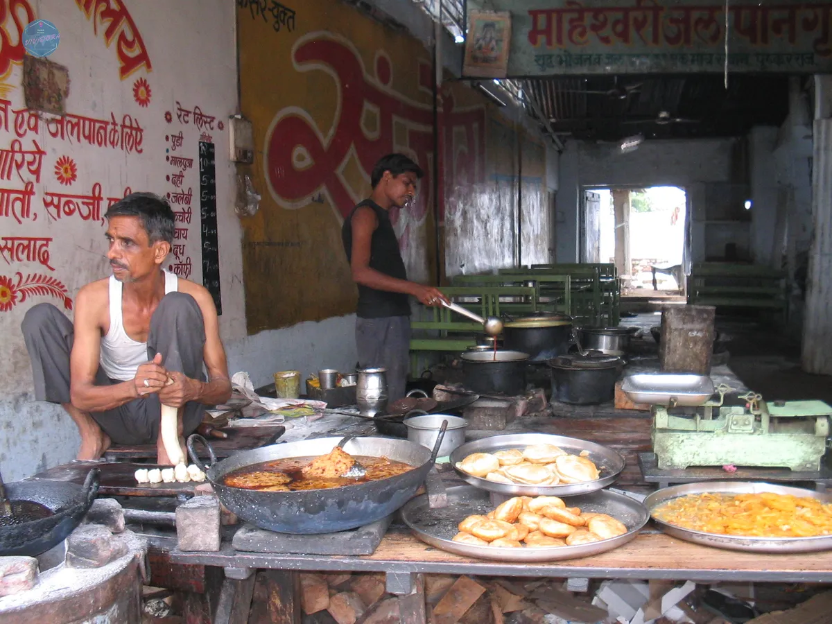Puesto de comida callejera con frituras en un mercado local de la India