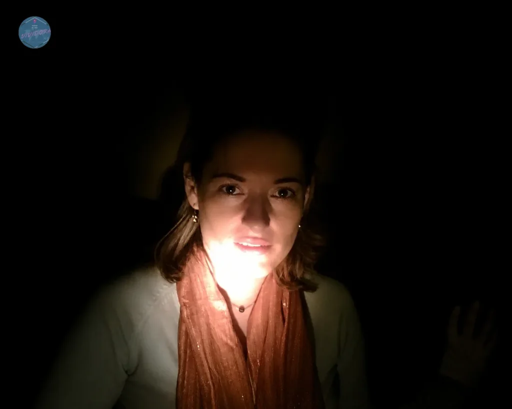 Viajera iluminada por una pequeña luz en plena oscuridad