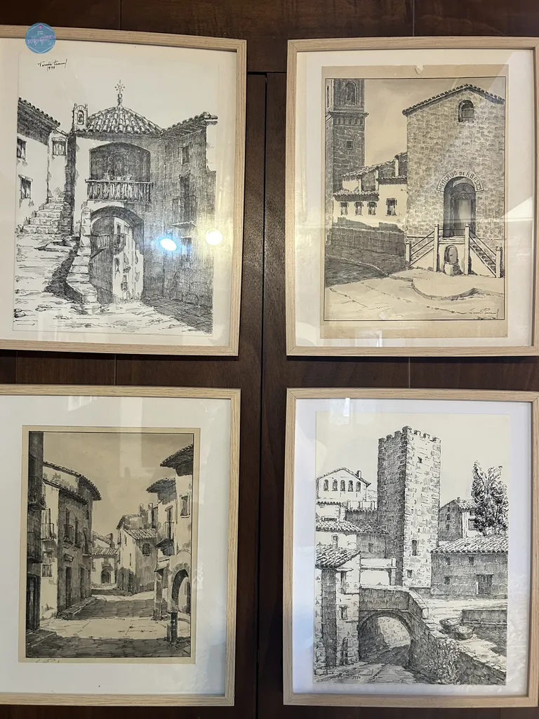 Cuatro ilustraciones enmarcadas con dibujos a tinta de rincones históricos y torres medievales de Benassal, expuestas en el Museo Teresita Pascual.