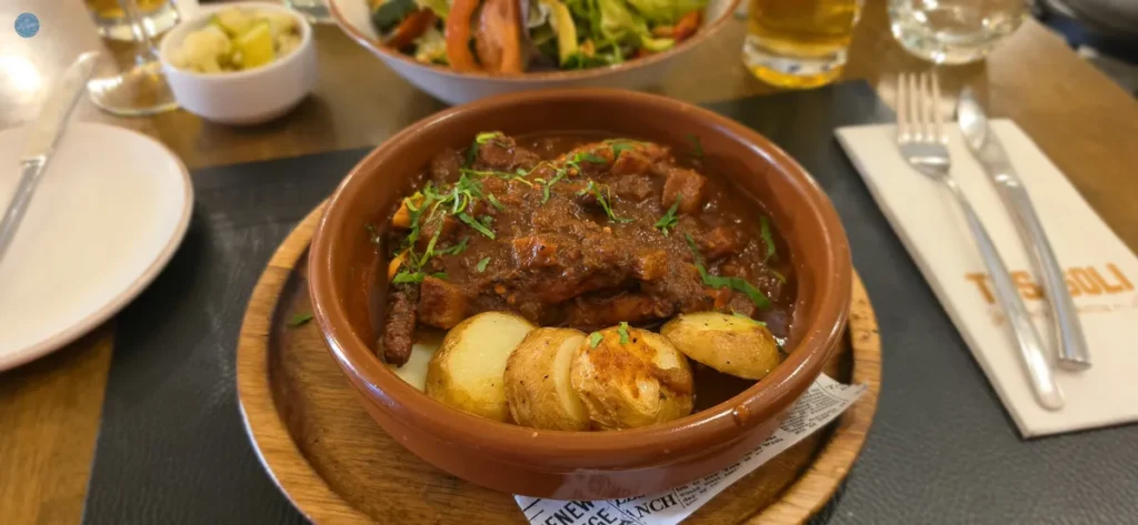 Fenkata, el guiso de conejo estofado plato nacional de Malta, servido en cazuela de barro con patatas asadas en el restaurante Tas-Soli de La Valeta