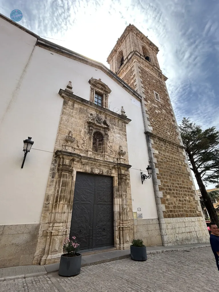 Fachada barroca y torre campanario de la Iglesia de la Asunción de Nuestra Señora en Benassal, reflejo del patrimonio histórico del Maestrazgo.