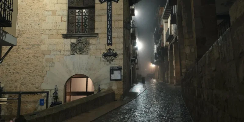 Vista panorámica nocturna de los soportales del Centro de Morella envueltos en bruma, una de las visitas imprescindibles que ver en Morella