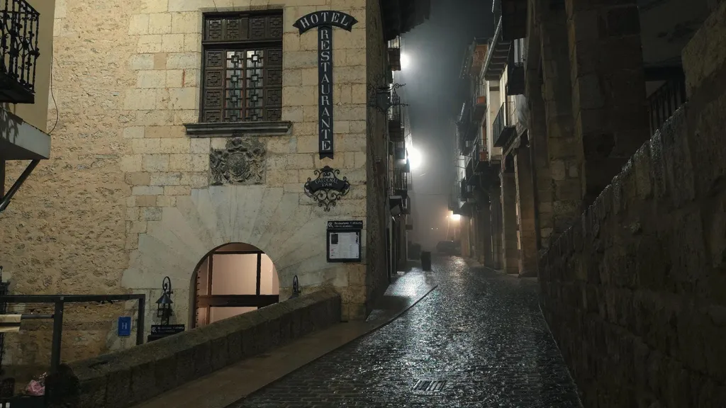 Vista panorámica nocturna de los soportales del Centro de Morella envueltos en bruma, una de las visitas imprescindibles que ver en Morella